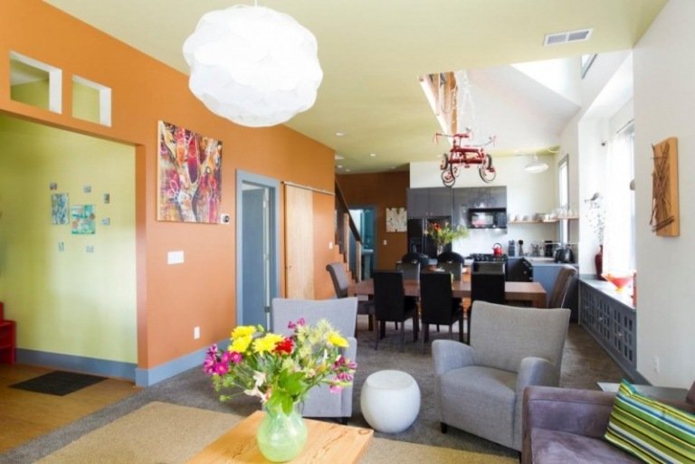 öppet-kök-vardagsrum-orange-gul-grå-stoppade möbler-vas-blommor-färgglada-intressant
