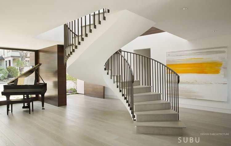 öppet-rum-design-ljusa-färger-modern-spiraltrappa-piano-konstverk-beige-golv