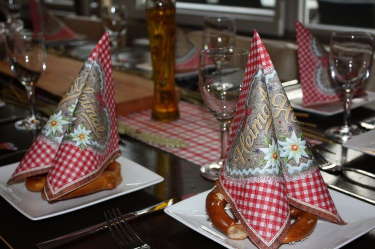 Oktoberfest spel servetter närbild kringlor bordslöpare röda vita vinglas