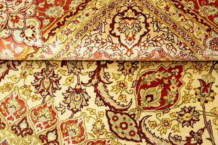 Orientalisk matta med detaljerade utsmyckade mönster i grädde, grönt och rött