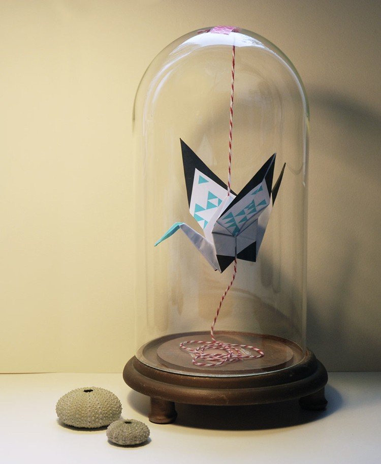 Origami -kran som hänger i en glasburkdekoration