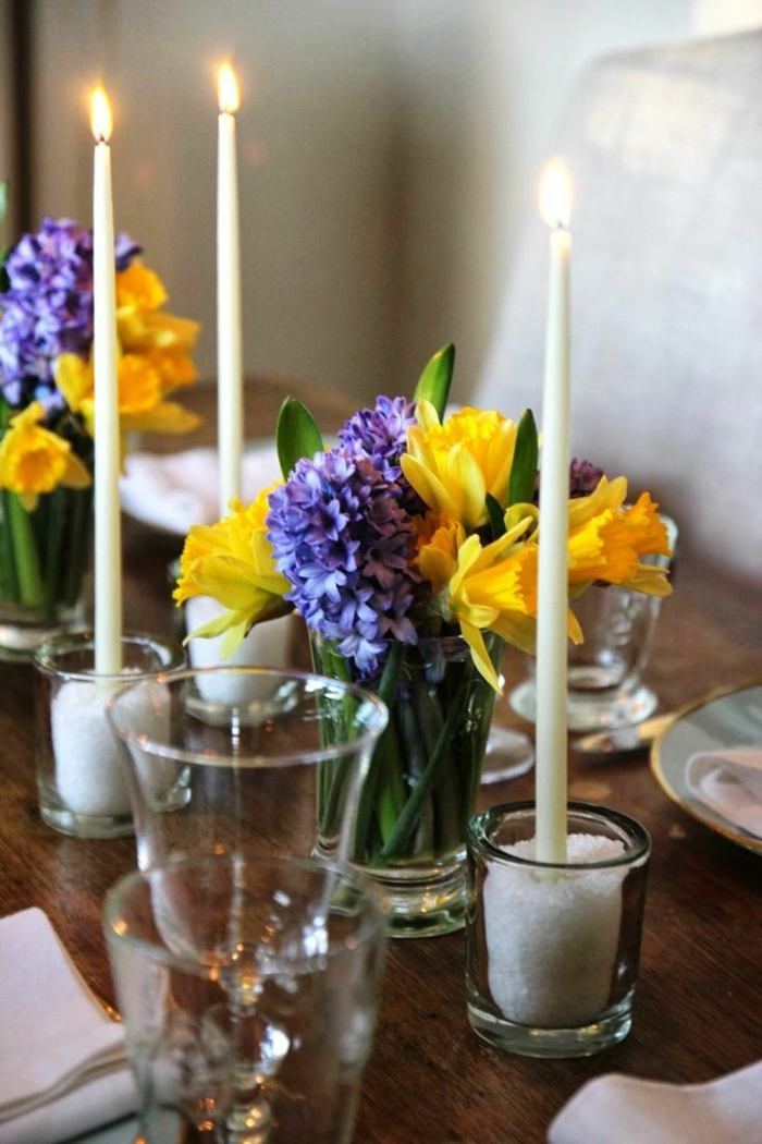 Påskbord dekoration av vårblommor hyzint blå påsklilja gula ljus