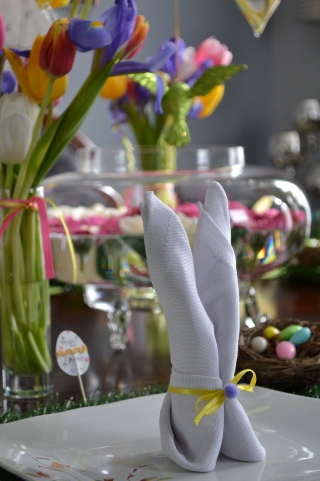 påsk dekoration idé bord servett kanin vikning gul rosett pompom