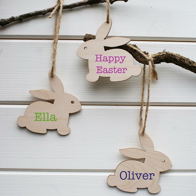 Kaniner-gjorda av trä-påsk-dekorationer-med-namn-på-trädgrenar