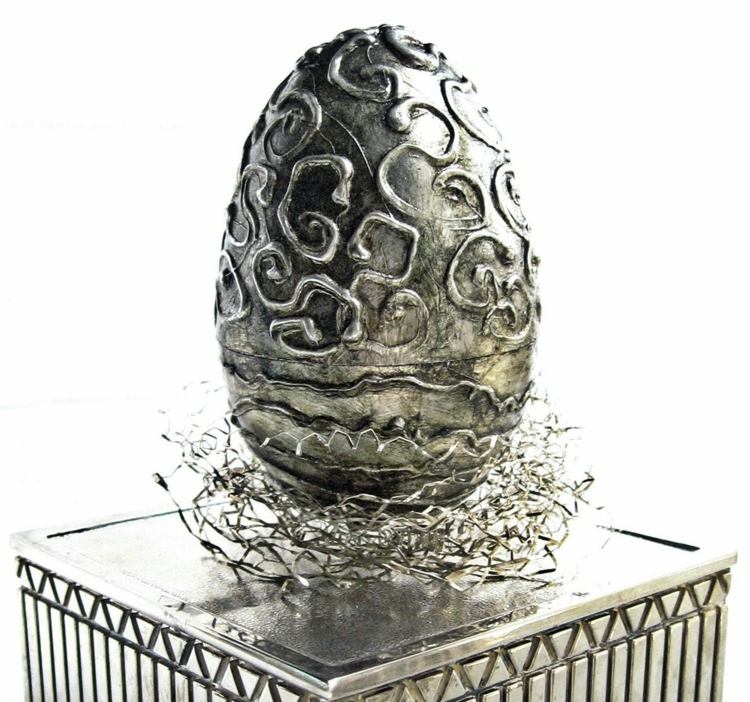 Silverdragonägg som dekoration till påsk med en modern påskkorg i metall