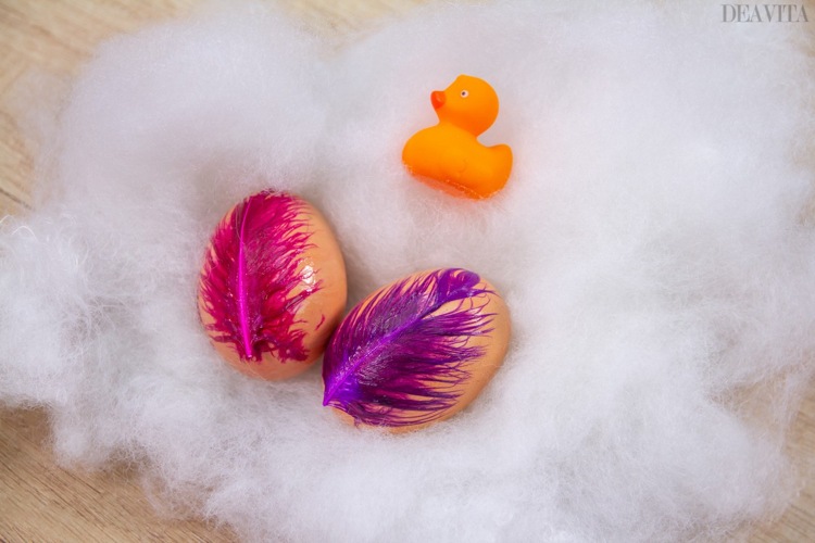 Dekorera påskägg med färgglada dekorativa fjädrar