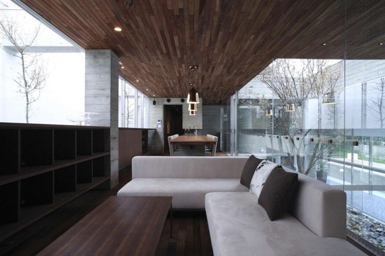 Panoramafönster-inre trädgård-minimalistisk-vardagsrum-soffa-grå-takpanel-trä-betong