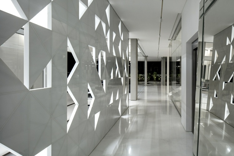 perforerat hus fasad aluminium exponerad betong vit sten skiljevägg trianglar geometriska mönster