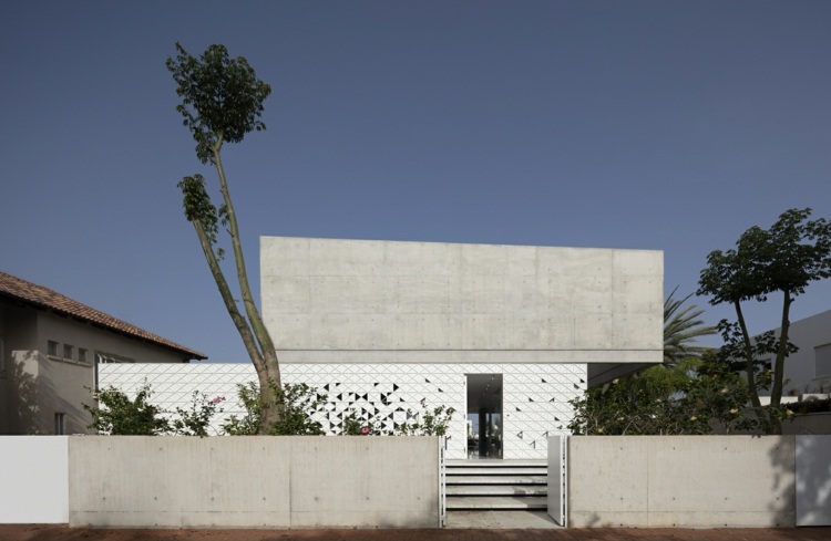 perforerad fasad d3 hus israel vit aluminium trianglar geometriskt mönster exponerad betong vinklad entré