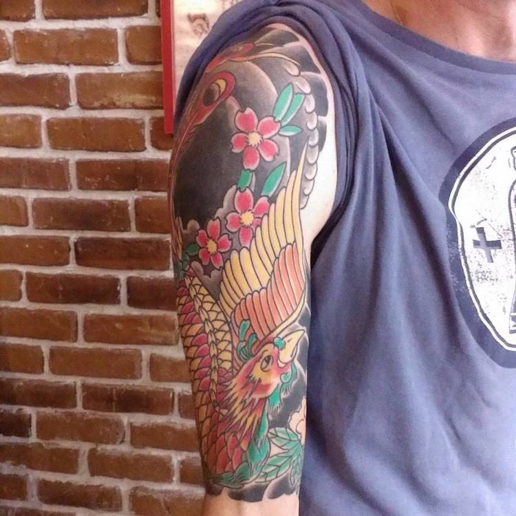 phoenix tatuering design tatueringar eld fågel japansk mytologi blommor röd gul svart överarm ärm placering