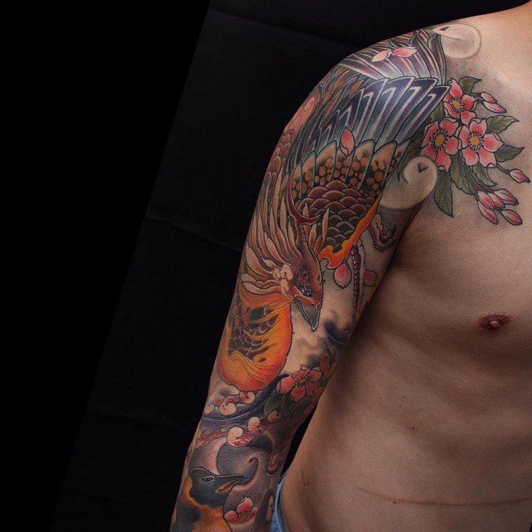 phoenix tatuering designer tatueringar eld fågel japansk mytologi blommor röd gul svart överarm placering
