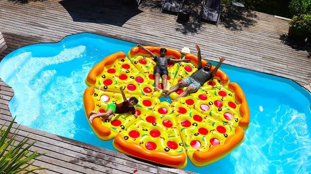 Bitar av uppblåsbar pizza som sätts ihop för pool för mer roligt på sommaren