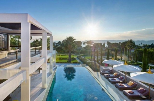 Fastighet modern infinity pool parasoll solstolar