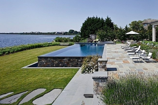 fristående pool natursten vägg trädgård design liggande stolar