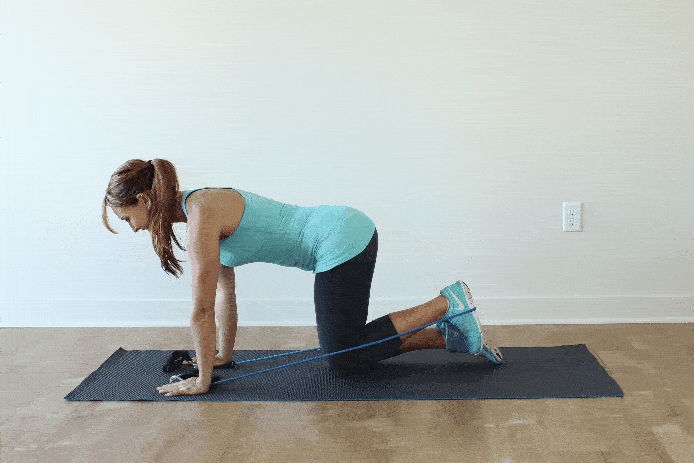 fitnessband utför övningar för glutealmusklerna på en matta med repetitioner