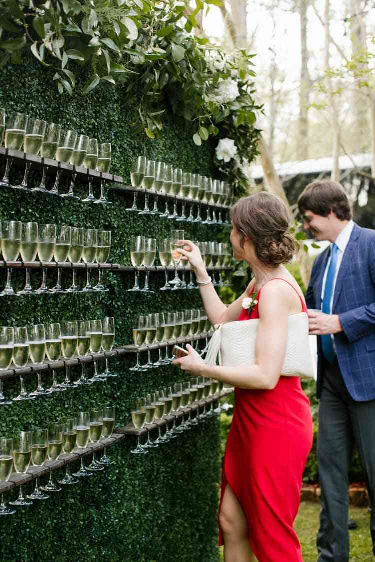 grön vägg med champagneglas som gästmottagning för bröllopet