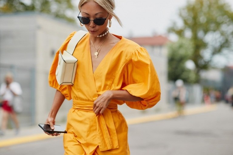 Klänning med puffärmar kombinerar gult läderväska blont hårdräkt sommarkvinnor