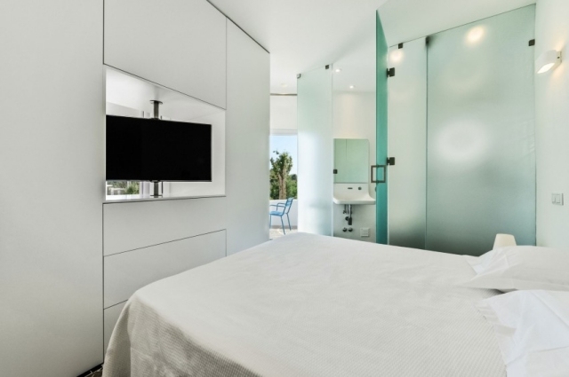 minimalistisk-svit-sovplats-inbyggd garderob-vit-badrum