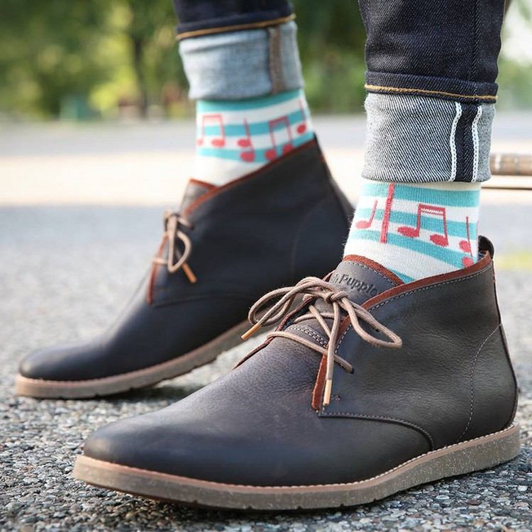 moderna färgade anteckningsstrumpor med ankelboots och tighta jeans som nuvarande herrmode