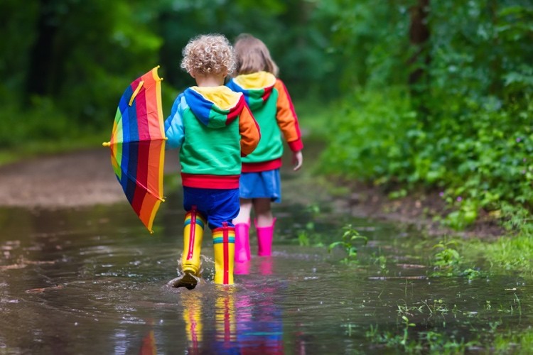 Barnens regnkläder färgglada stövlar och regnjacka och paraply