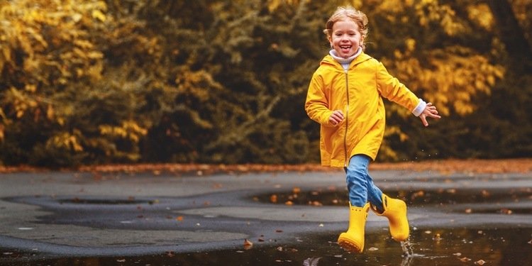 Rainwear barnflicka med gula gummistövlar och regnrock