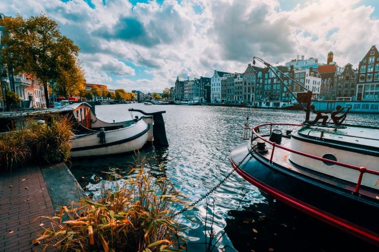 Traditionella båtar på vattnet i Amsterdams kanal i Nederländerna som resmål på hösten