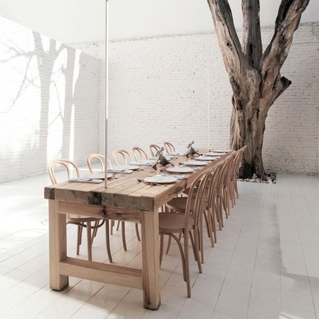 Tegel-vägg-död-träd-massivt trä-bord-med-stolar