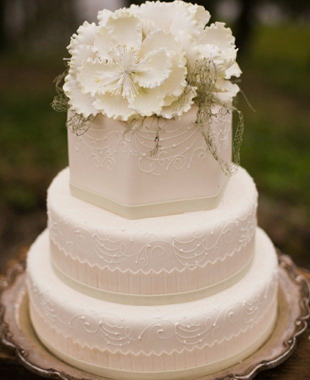 Bröllopstårta vitt socker blommor graverade band