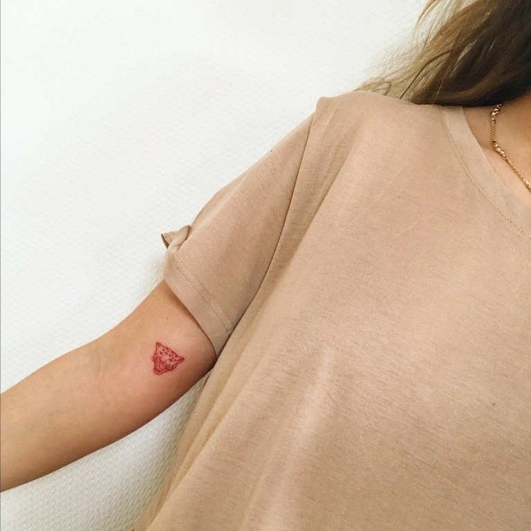 Små, röda tatueringar som en trend för kvinnor - leopard nära armbågen