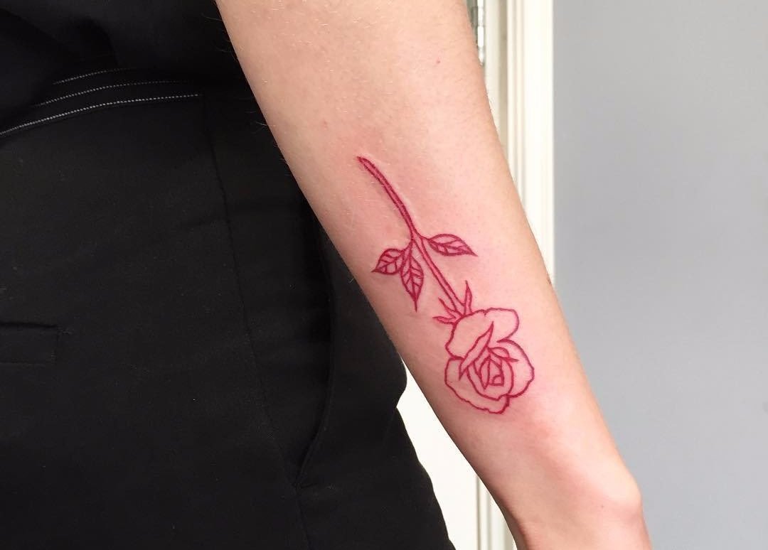 Få en skissartad tatuering av en röd ros upp och ner