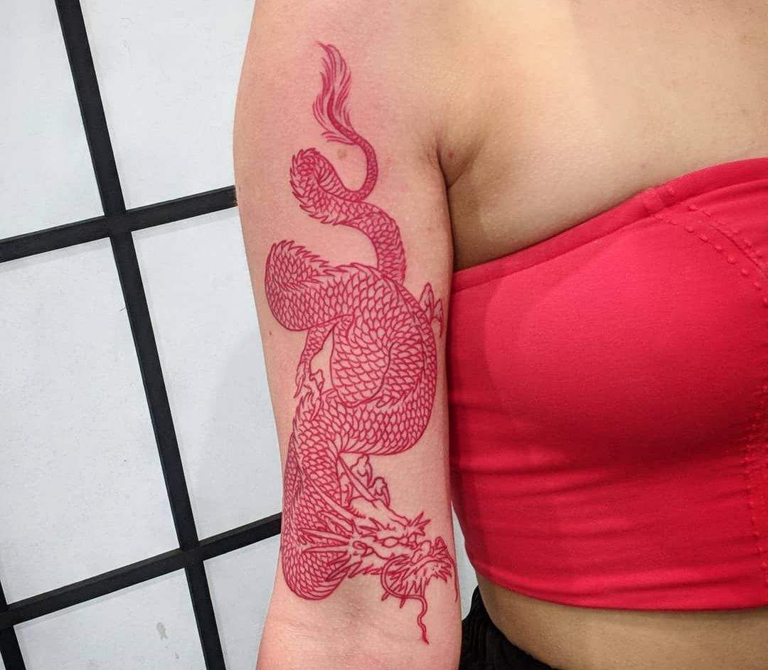 Röd drake på armen med aiatisk symbolik