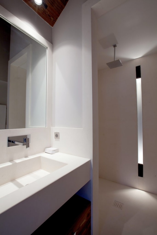badrumsdesign vit handfat i linjär design vägglampa led