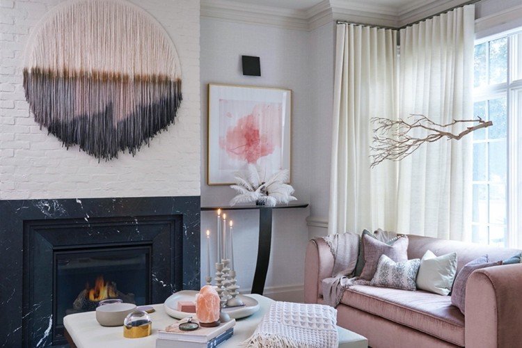 Lyxigt vardagsrum med öppen spis i rosa och vit saltlampa som dekoration på soffbordet