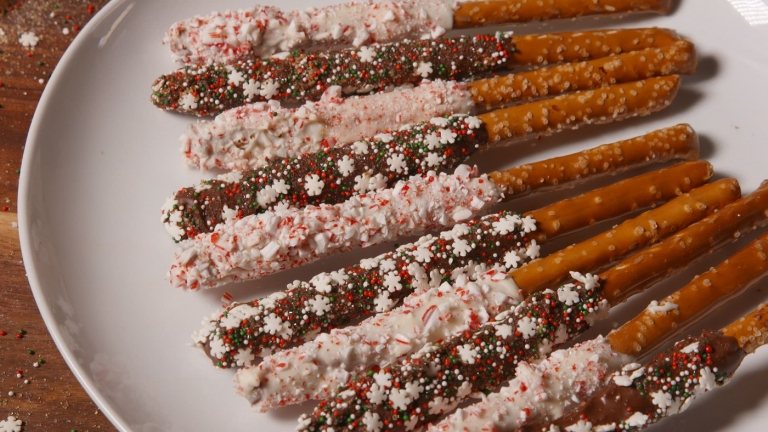 Grädda godis till jul Dekorera kringlpinnar med strössel och häll vit choklad över dem