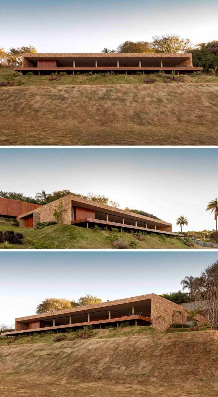 Sandstensväggar, hus med platt tak, träterrass på en sluttning