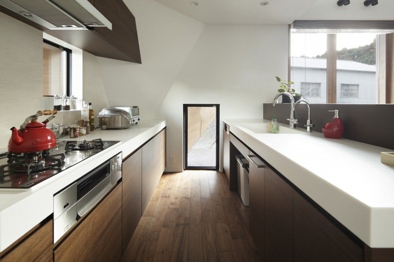 Designa ett modernt kök under sluttande tak, handtagsfria träfronter och vit bänkskiva