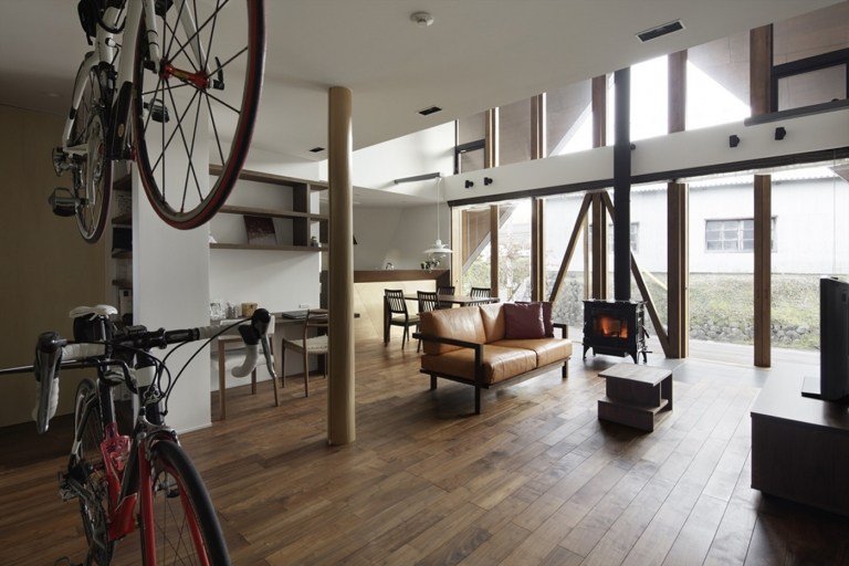 Vardagsrum med förvaringsutrymme för cyklar och modern inredning i skandinavisk stil