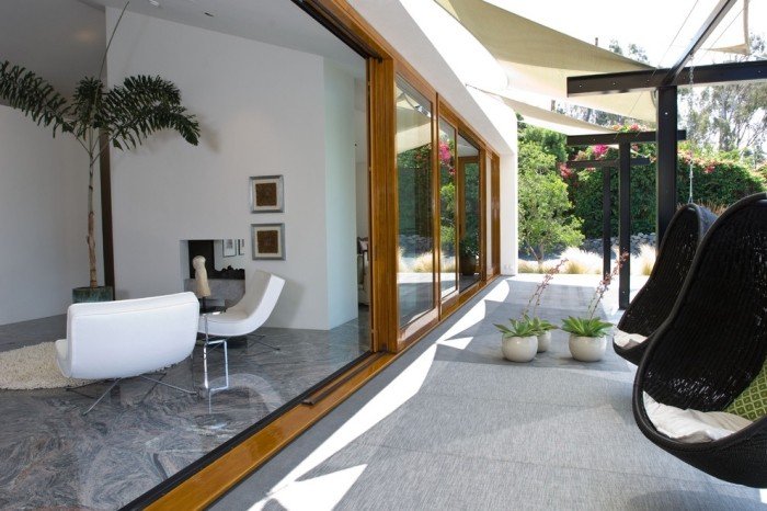 Glasade-terrass-dörrar-på-sommaren-lämna-öppna-hängande-stolar-exotiska