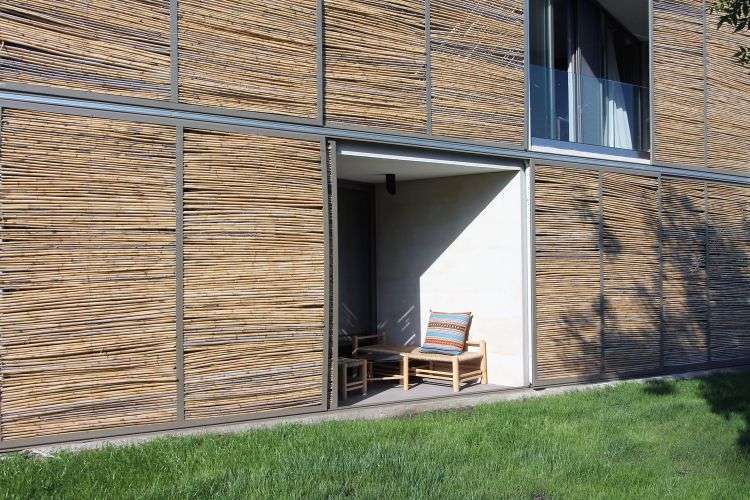 gräsmatta fasad vass ram strukturella stål trädgårdsmöbler terrass balkong betongväggar skjutbara glasdörrar paneler