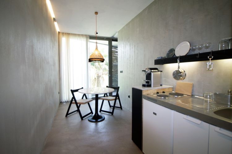kök minimalistiska hängande lampstolar betongväggar sjunka spishäll kaffebryggare köksredskap