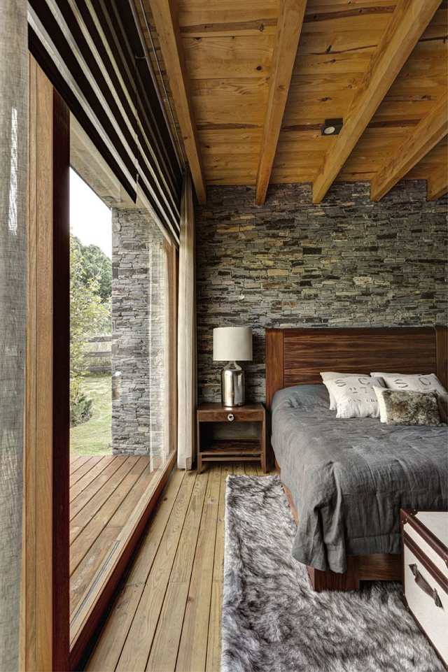 sovrum design rustikt trägolv pälsmatta natursten vägg tak i trä