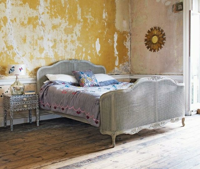 Sovrumsmöbler säng sängbord gul väggfärg faller av