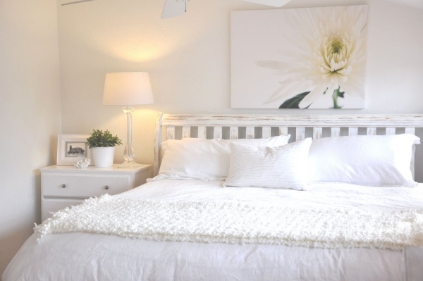 Sovrum helt i vita blomstermålningar över sängen