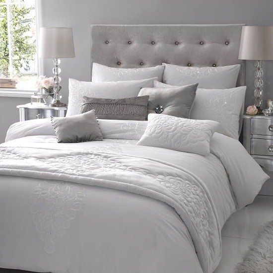 Sovrum helt vitt och grått med en kombination av vadderad sänggavel