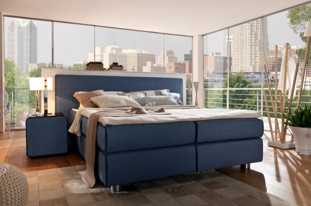 Design-i-blå-box-vår-säng-sovrum-med-väggar-gjorda av glas