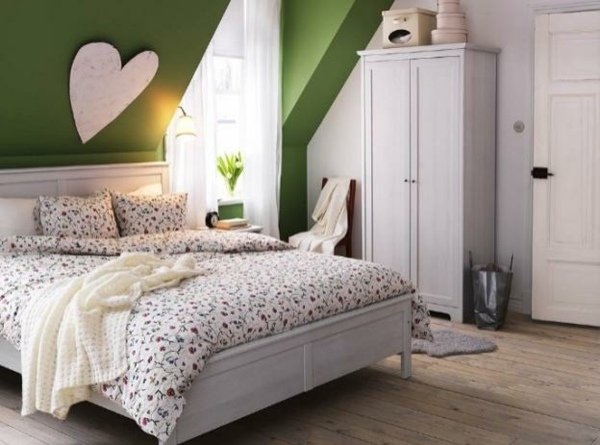 Sovrum-med-sluttande-tak-grön-accent vägg-skåp