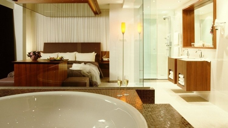 Sovrum med bubbelbadkar-mosaikstenar-glasvägg-säng-badrum-öppet