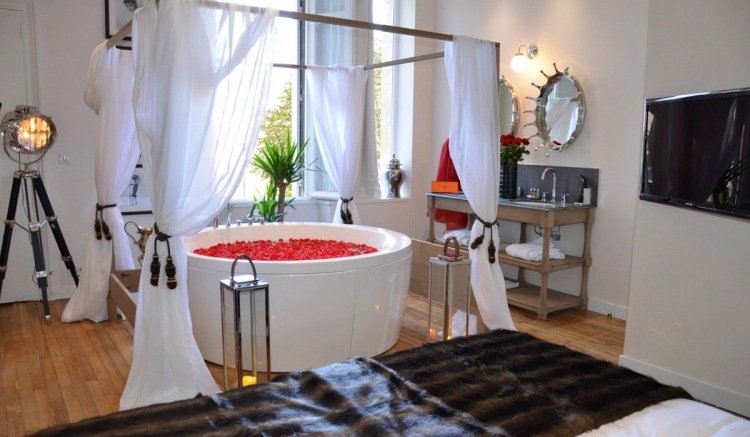 Sovrum med bubbelpool-runt-vitt-trägolv-rosor-blad-romantik