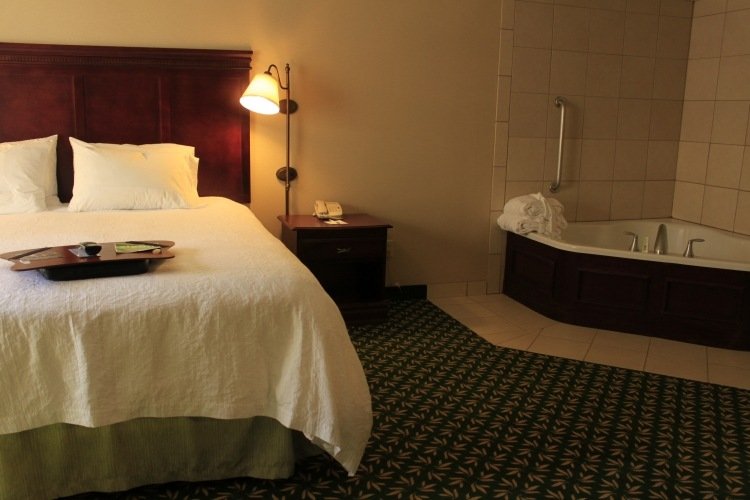 sovrum-bubbelpool-hotellrum-matta-nattlampa-säng-sängkläder-kuddar
