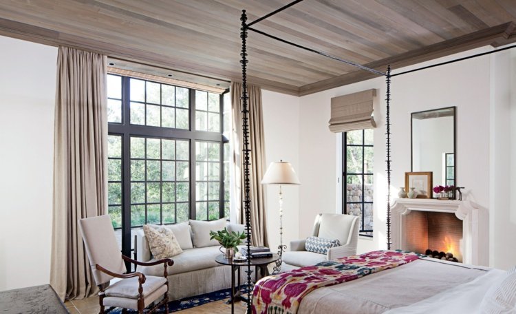 gardin-design-sovrum-beige-stort-fönster-öppen spis-himmelsäng-prydnader